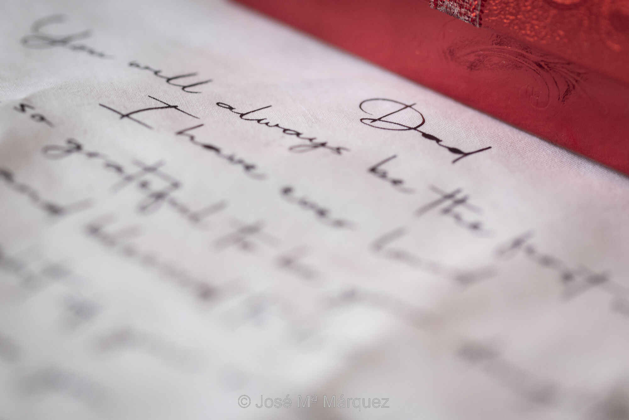 Macrofotografía de un texto en inglés de la novia ha dirigido su padre. Es un detalle fotográfico que da contexto emocional al reportaje de boda durante los preparativos de la novia en el hotel. Foto de José María Márquez. Fotógrafo de bodas en Granada. Fotografía en macro de un texto en inglés que la novia dirige a su padre. Horizontal y en color. El detalle fotográfico está enfocado a la palabra “Dad” (Papi) que encabeza el texto. El resto del texto apenas se intuye porque queda suavemente fuera de foco, pero es una declaración de amor y agradecimiento a su padre por todo el cariño y apoyo que le ha dado toda su vida. La foto de este detalle se complementa la narrativa de otras fotos del mismo momento, donde la novia le hace entrega al padre y a la madre de unos regales que van acompañados de sendos pañuelos con sendos mensajes. Es una bella fotografía que habla del amor de la novia a sus padres. Aporta información sobre la personalidad de la novia y la idiosincrasia familiar. Es una fotografía de José María Márquez, fotógrafo de bodas en Granada.