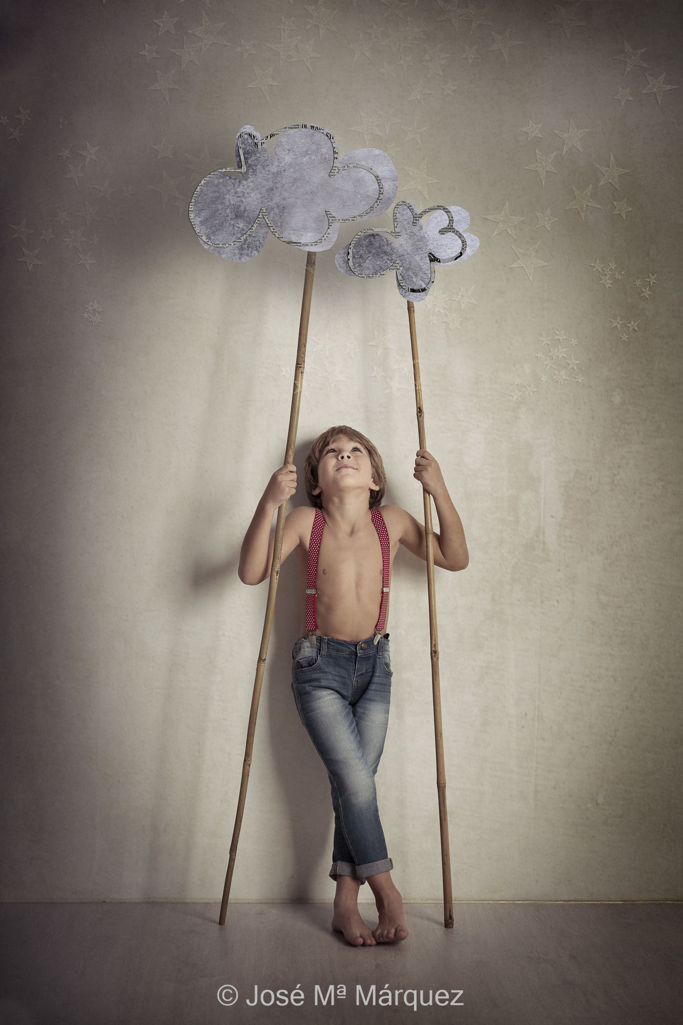 Foto de un niño en estudio. Fotografía escenificada con temática Tom Sawyer. Pinchando las nubes con cañas. Fotógrafo infantil de Granada José Mª Márquez