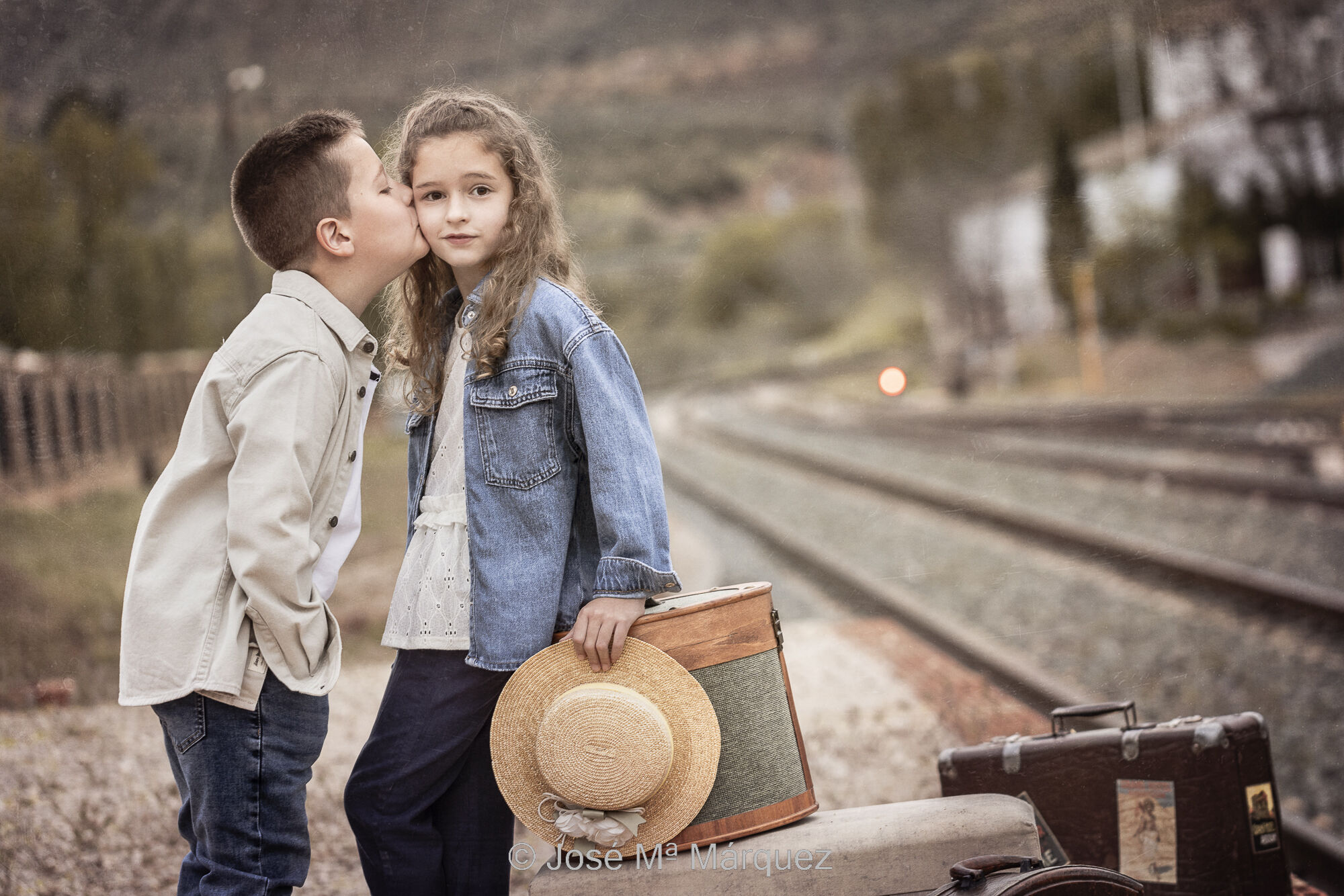 José María Márquez. Fotógrafo de Granada.  - dos-hermanos-de-comunion-el-nino-da-un-beso-en-la-cara-a-su-hermana-mayor-en-anden-de-una-estacion-esperando-el-tren-reportajes-de-comunion.jpg