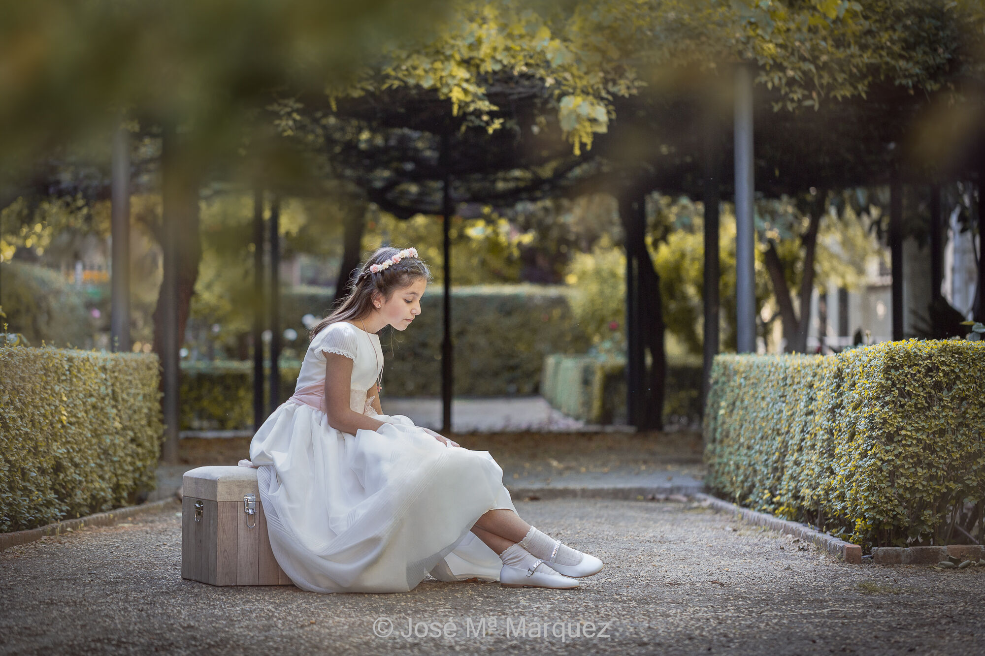 José María Márquez. Fotógrafo de Granada.  - foto-de-una-nina-sentada-en-baul-mirandose-zapatos-con-vestido-de-primera-comunion-sesion-exteriores-luz-natural-fotografo-granada.jpg