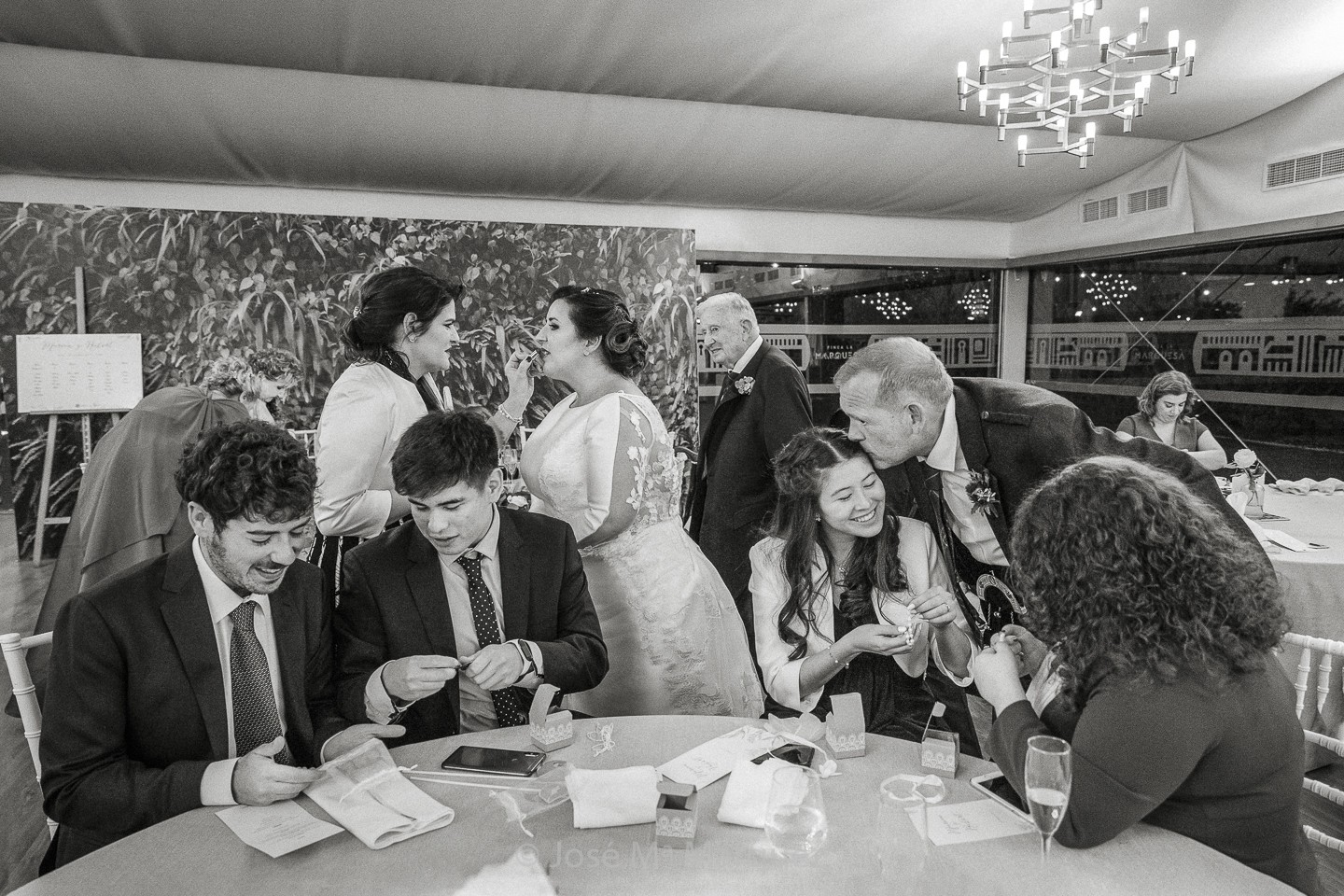 Fotografía instantánea real y natural. Fotoperiodismo de boda Narrativo. Novio y novia interactúan con invitados en el convite