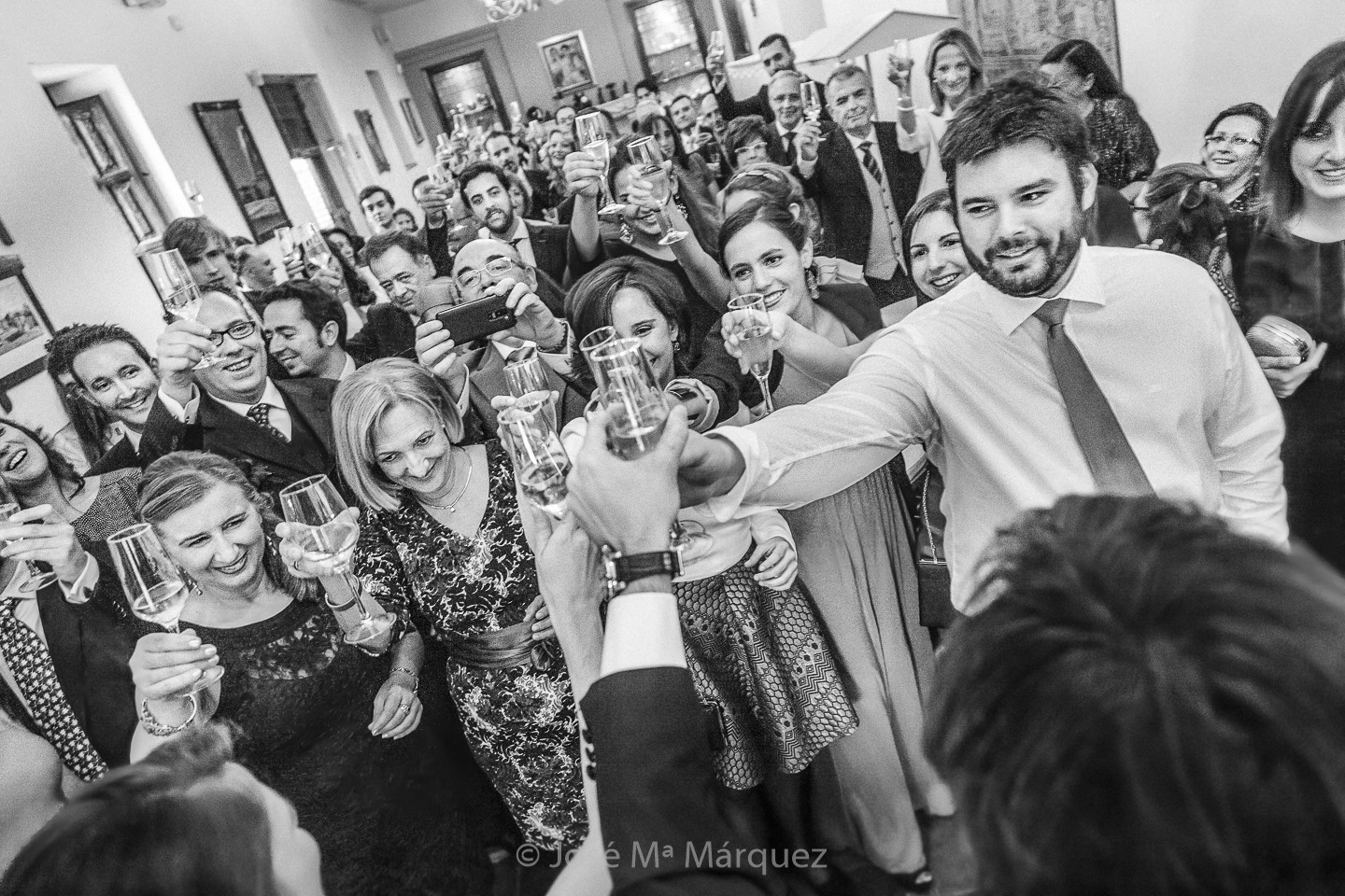 Los novios brindan con todos los invitados de la boda. Fotografía documental instantánea de fotógrafos de boda en Granada.