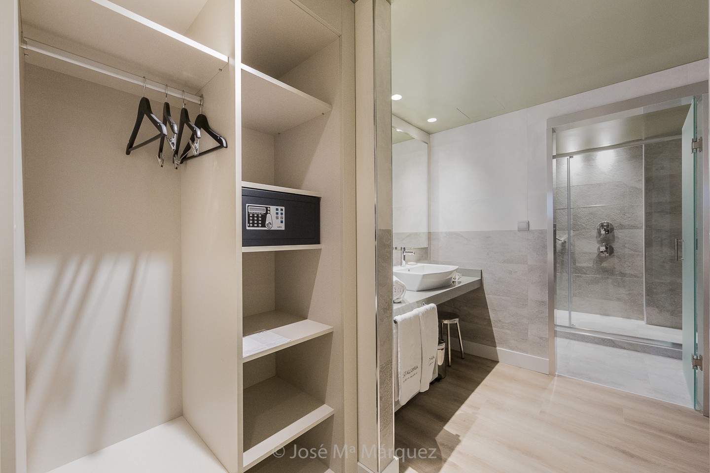 Baño con lavabo de un seno y zona de ducha independiente con detalle de caja fuerte en armario. Fotografia publiciaria