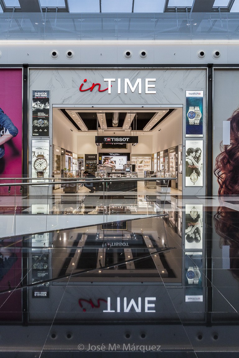 Fachada relojería In Time con reflejo de la marca. Fotogafía profesional para empresa en Granada 