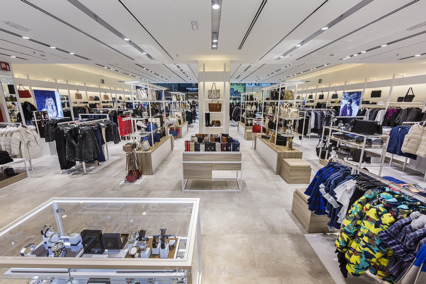 Moda y complementos Guess. Vitrina con relojes, percheros y estanterias ropa y expositores complementos. Foto publicitaria Granada 