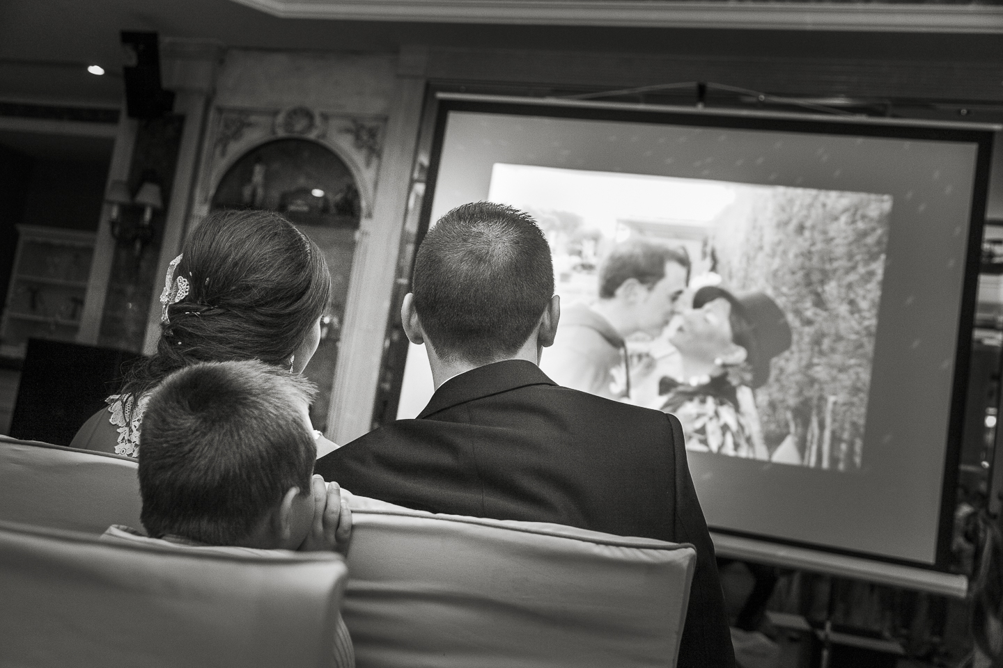 Instantánea de Boda. Los novios ven un vídeo multimedia regalado por los amigos durante la celebración